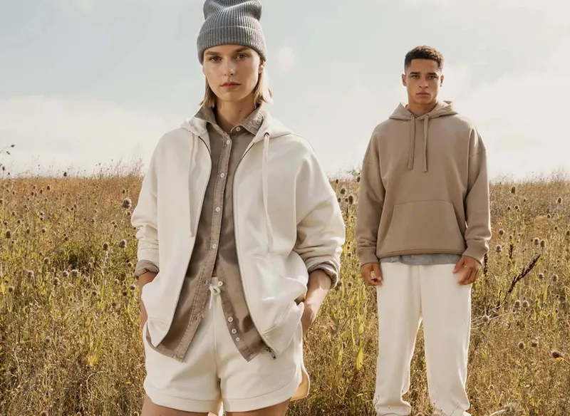 Zwei Männer in hellen Hoodies und Jacken in einem Getreidefeld