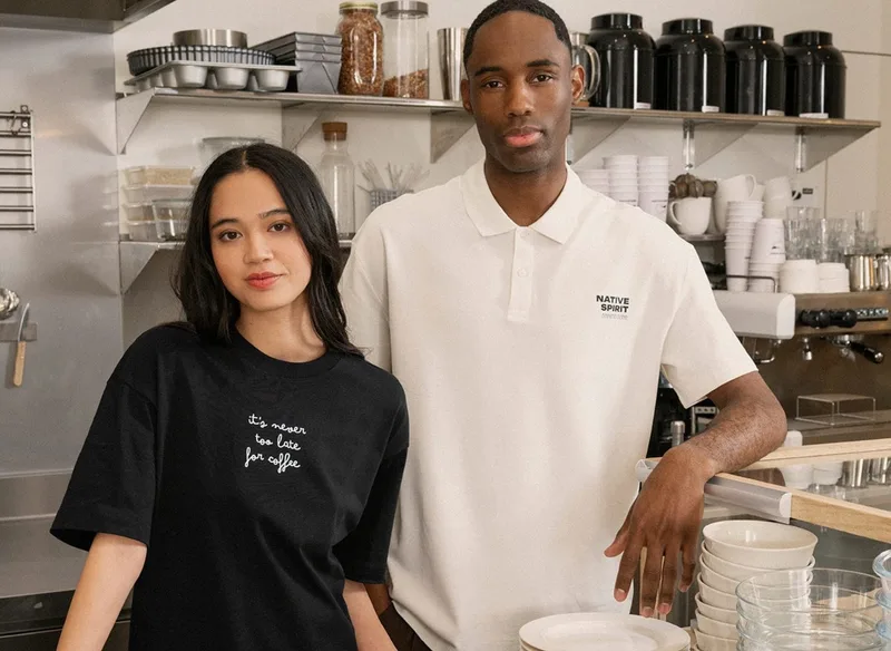 Frau und Mann in bedrucktem T-Shirt bzw. Polo im Coffeeshop