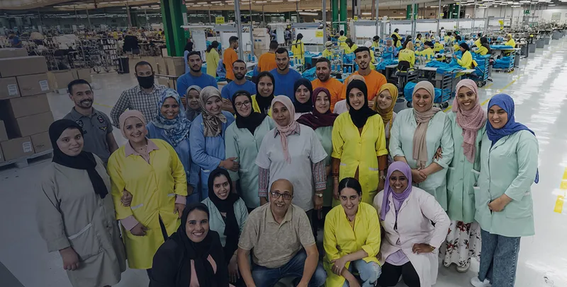 Gruppenfoto der Belegschaft in einer Nähfabrik