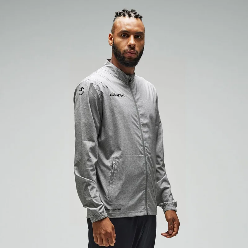 Mann in grauer uhlsport-Jacke, grauer Studiohintergrund
